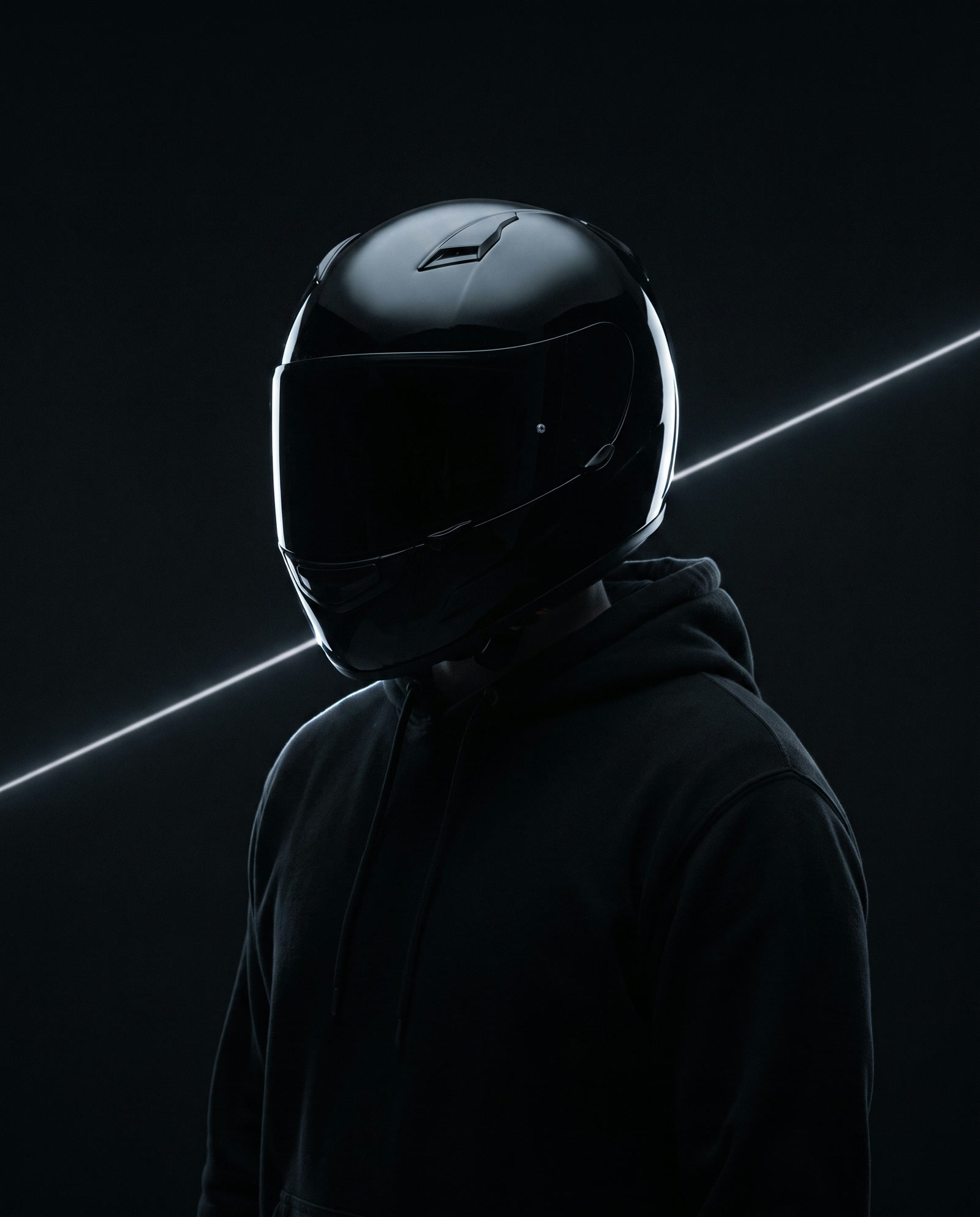 Immanuel: a figure in a closed black motorcycle helmet, the systems side of the cluster